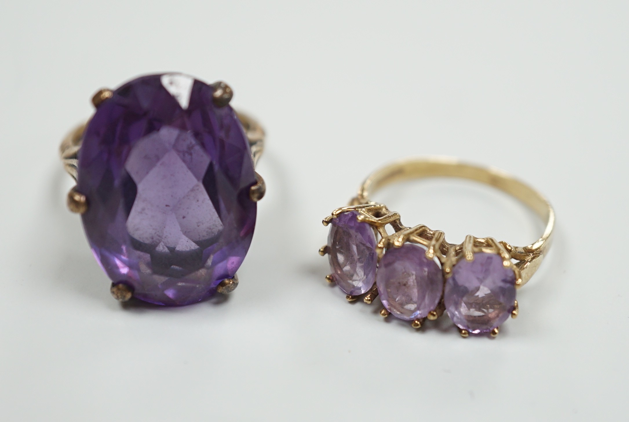 A modern 9ct gold and three stone amethyst set half hoop ring and a 9ct gold and synthetic colour change corundum set dress ring, gross weight 12.4 grams.